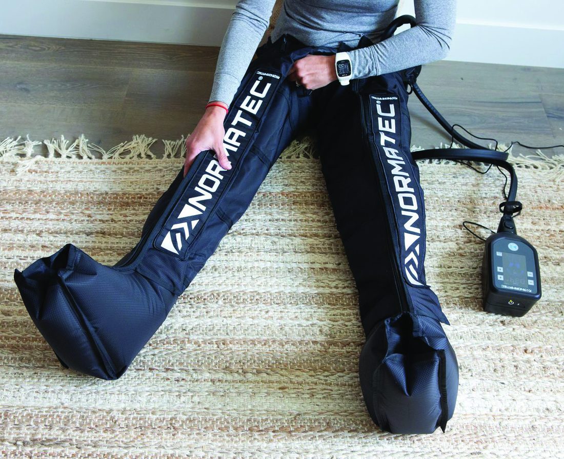 NormaTec compression boots being worn while seated